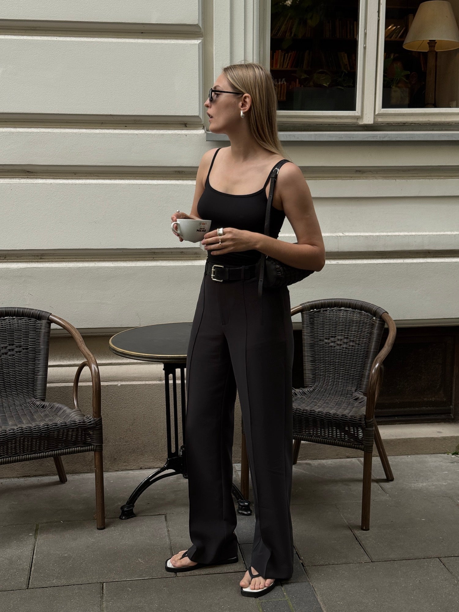 Woman wearing Ninepine black strappy tank top with crepe relaxed pants in black, styled as a minimal and effortless summer outfit.